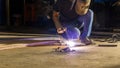 worker welding metal, focus on flash light line of sharp spark,in low light Royalty Free Stock Photo