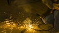 worker welding metal, focus on flash light line of sharp spark,in low light Royalty Free Stock Photo