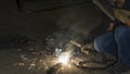 worker welding metal, focus on flash light line of sharp spark,in low light Royalty Free Stock Photo