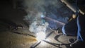 worker welding metal, focus on flash light line of sharp spark,in low light Royalty Free Stock Photo