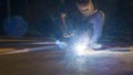 worker welding metal, focus on flash light line of sharp spark,in low light Royalty Free Stock Photo