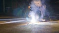 worker welding metal, focus on flash light line of sharp spark,in low light Royalty Free Stock Photo