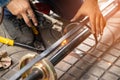 The worker is welding metal part of the details of the system rolling lifting gate.