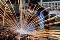 Worker is welding repair automotive part in car factory