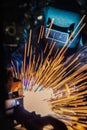 Worker is welding repair automotive part in car factory