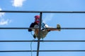 Worker welding the steel structure of roof with arc welding machine and blue sky in background