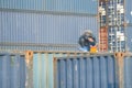 Worker welding to repair container box in port