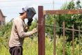 A worker welds metal for a fence