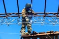 A worker welds metal onto the canopy frame.