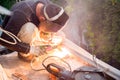 The worker welds metal structures on the balcony. A professional specialist repairs the iron reinforcement of the balcony plate Royalty Free Stock Photo