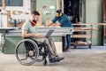 Worker in wheelchair with computer in a carpenter`s workshop with his colleagu Royalty Free Stock Photo