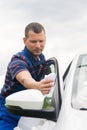 Worker, wipes the car door, with a white rag Royalty Free Stock Photo