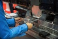 Worker working in factory in metal sheet bending process