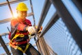 A worker working at height equipment. Fall arrestor device for worker with hooks for safety body harness on the roof structure. Royalty Free Stock Photo