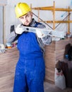 Worker is working with level near the wall at the object indoors. Royalty Free Stock Photo