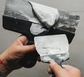 Worker working manual with wall plastering tools inside a house