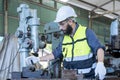 Worker is working in a steel factory. Engineer with monitor checking quality result of work Royalty Free Stock Photo