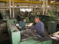 a worker works on a lathe in a Soviet era machine shop Royalty Free Stock Photo