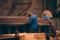 Worker in workshop processes large cast iron part after casting in metallurgical foundry plant Royalty Free Stock Photo