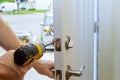 man repairing the doorknob. closeup of worker& x27;s hands installing new door locker Royalty Free Stock Photo