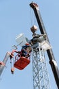 Workers on the aerial platform with the help of a crane carry out the installation of the wind generator
