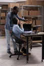 Workers analyzing transportation logistics while checking metallic box delivery order on laptop Royalty Free Stock Photo