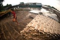 Workers ashore carrying bamboo.