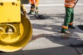 Workers on Asphalting paver machine during Road street repairing works. Street resurfacing. Fresh asphalt construction