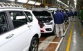 Workers assemble a car on assembly line in car factory