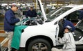 Workers assemble a car on assembly line in car factory