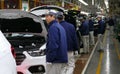 Workers assemble a car on assembly line in car factory