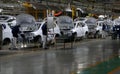 Workers assemble a car on assembly line in car factory