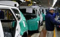 Workers assemble a car on assembly line in car factory