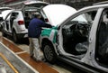 Workers assemble a car on assembly line in car factory