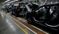 Workers assemble a car on assembly line in car factory