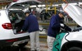 Workers assemble a car on assembly line in car factory