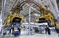 Workers assembles cars at automobile assembly line production plant