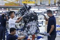 Workers assembles cars at automobile assembly line production plant