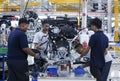 Workers assembles cars at automobile assembly line production plant