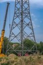 workers assembling a power pole at high altitude