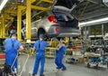 Workers on the assembly conveyor of automobile plant