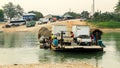 Workers in a boat with their vehicles crossing the river in Guatemala