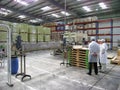 Workers of Bonduelle maize processing factory stand by a conveyor and discuss issues of can production. Cannery interior view