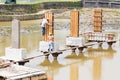 Workers building bridge foundation across lake Royalty Free Stock Photo