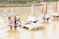 Workers building bridge foundation across lake Royalty Free Stock Photo