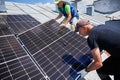 Workers building solar panel system on roof of house. Men installing photovoltaic solar module Royalty Free Stock Photo
