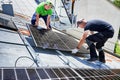 Workers building solar panel system on roof of house. Men installing photovoltaic solar module Royalty Free Stock Photo