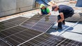 Workers building solar panel system on roof of house. Men installing photovoltaic solar module Royalty Free Stock Photo