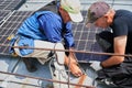 Workers building solar panel system on roof of house. Men installing photovoltaic solar module Royalty Free Stock Photo