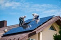 Workers building solar panel system on roof of house. Men installing photovoltaic solar module Royalty Free Stock Photo